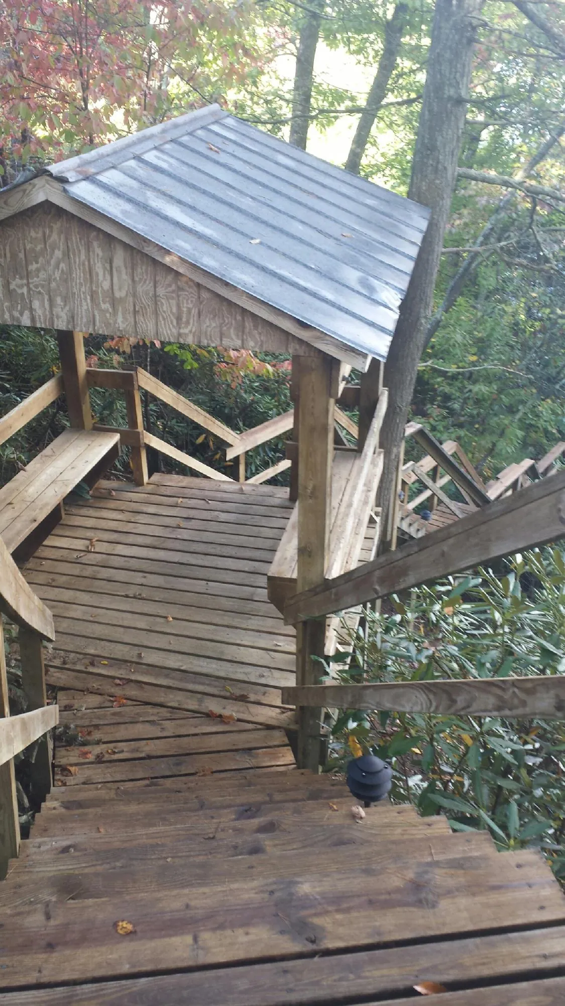 Metal roofed shelter over wooden steps on a wooded walkway — Skylight Repair & Installation work by our crew in Hopewell Junction