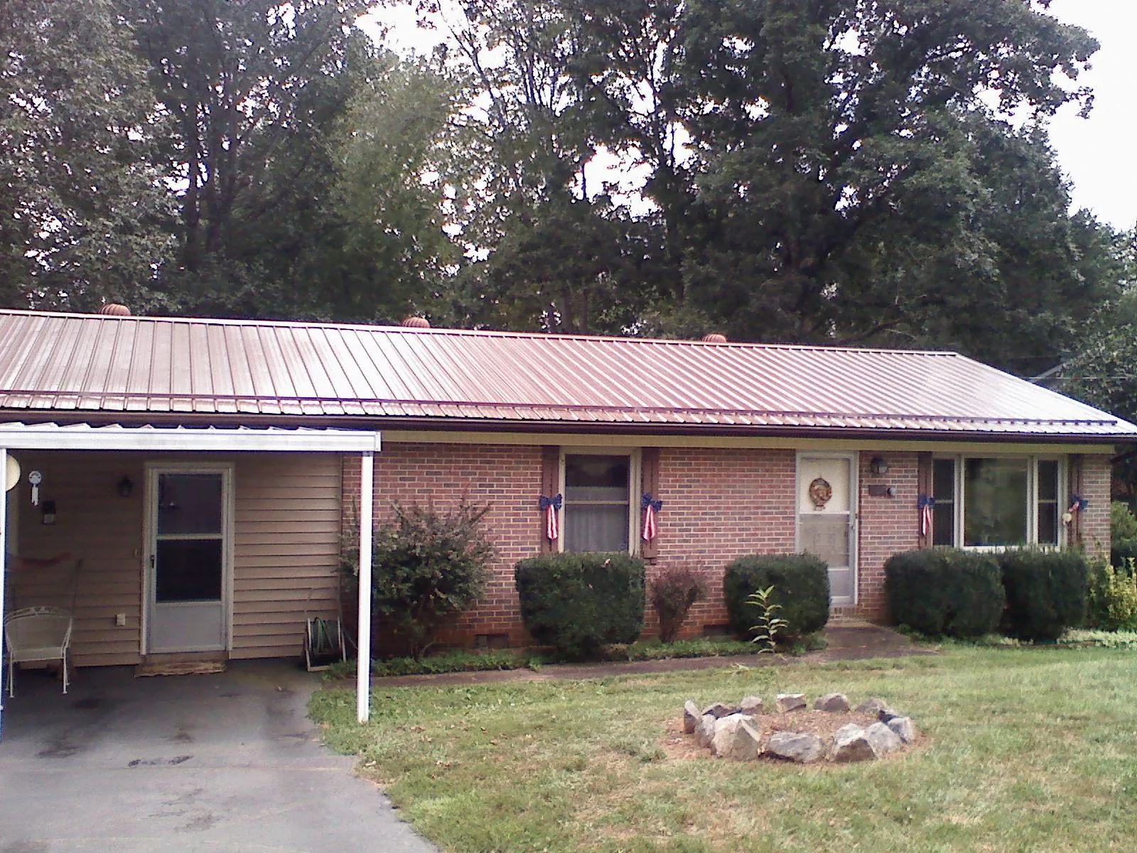 Bronze metal roof and carport on a brick ranch home — Roof Repair work by our crew in Hopewell Junction
